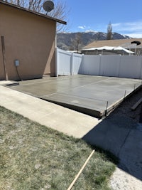 a backyard with a concrete patio and a fence