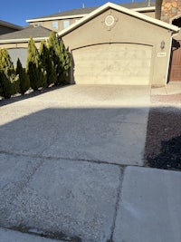 a house with a driveway and trees in front of it